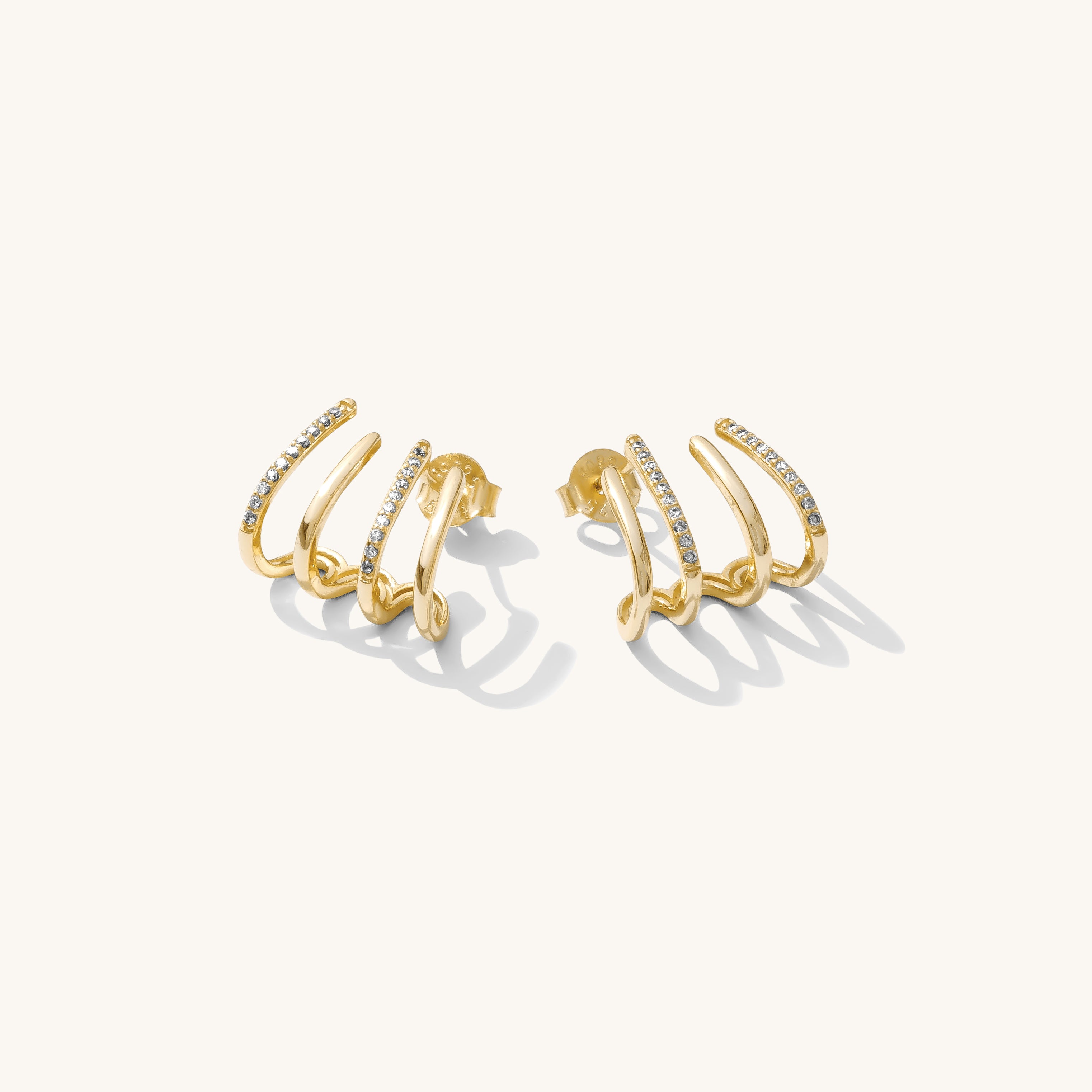 Close up of gold accent earrings on a white background