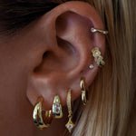 Close-up of an ear with multiple gold earrings