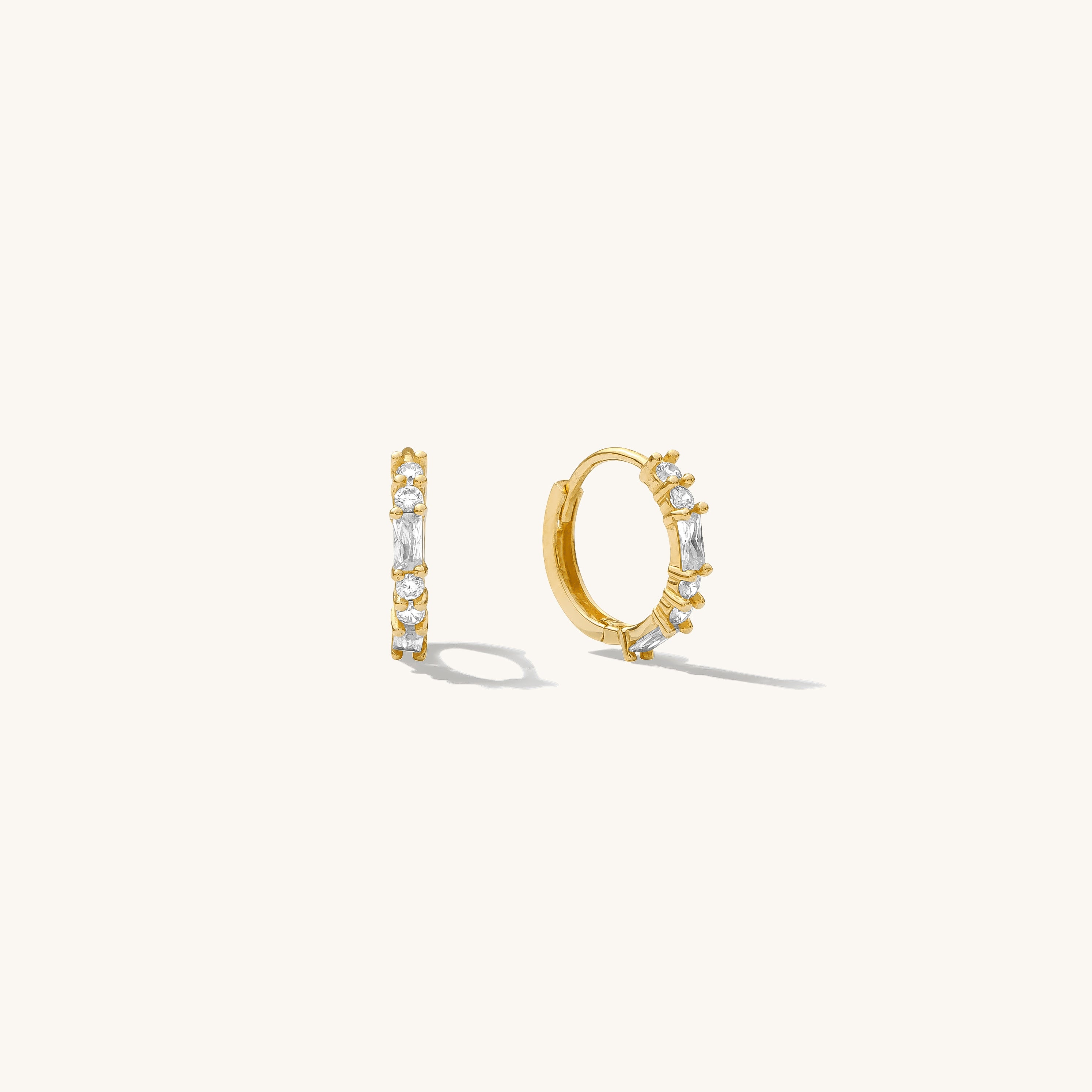 Close up of gold hoops with stones on a white background