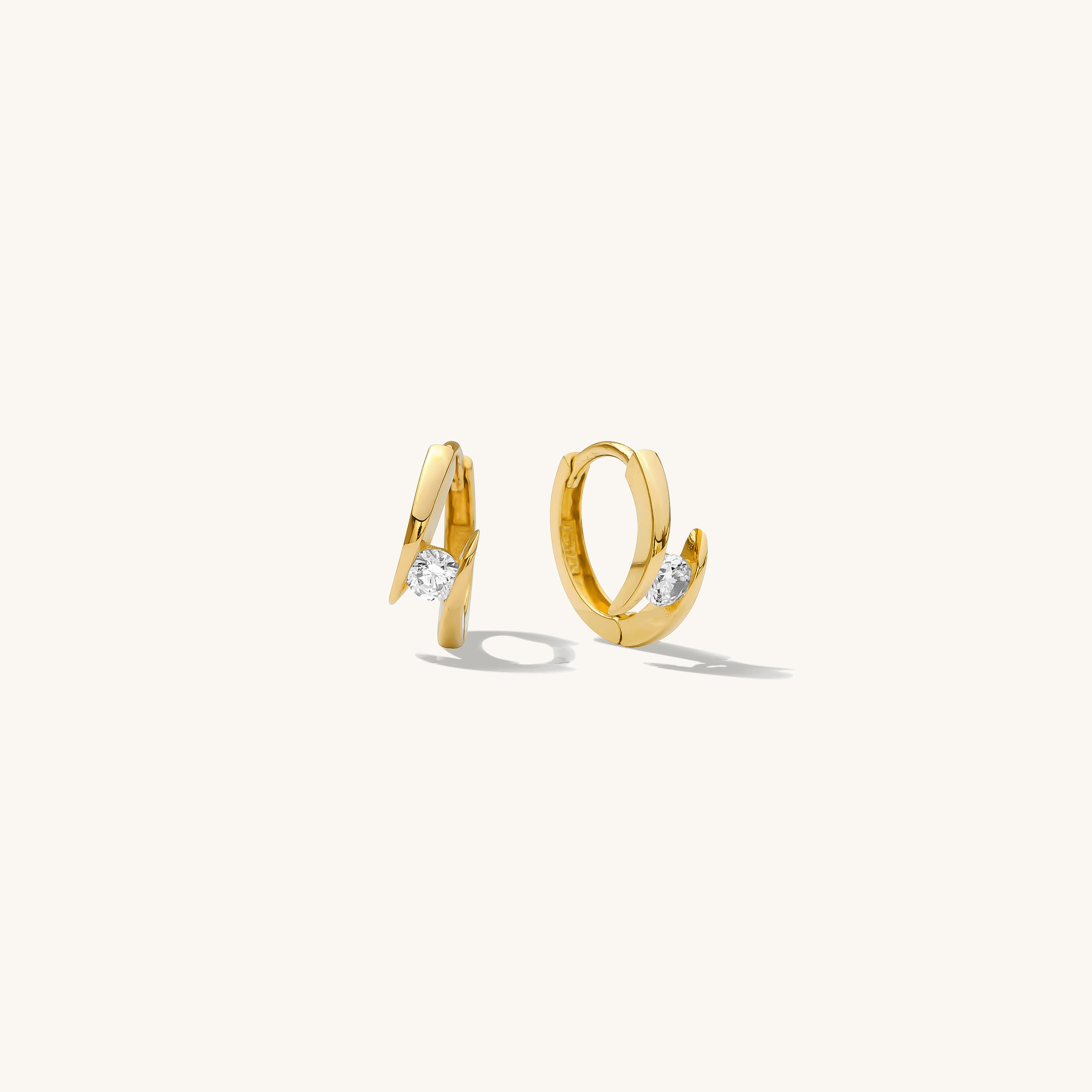 Close up of gold hoops with stones on a white background