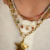 Close-up of a gold chain necklace with a star pendant on a white background