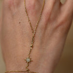 Gold bracelet with star design on a wrist against a neutral background
