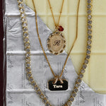 Three necklaces with different pendants on a textured surface