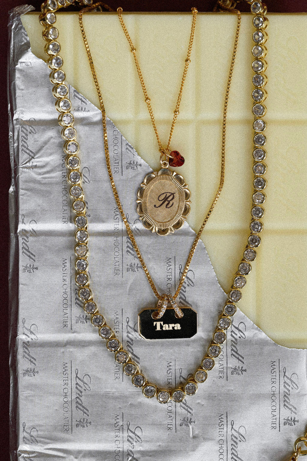 Three necklaces with different pendants on a textured surface