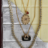 Three necklaces with different pendants on a textured surface