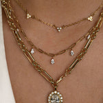 Layered gold necklaces with pendant on a person's neck