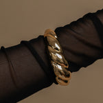 Gold bracelet on a black mesh background