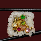 Close-up of multiple brightly colored stone earrings pictured in a piece of sushi