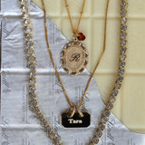 Gold necklaces with decorative elements on a textured surface