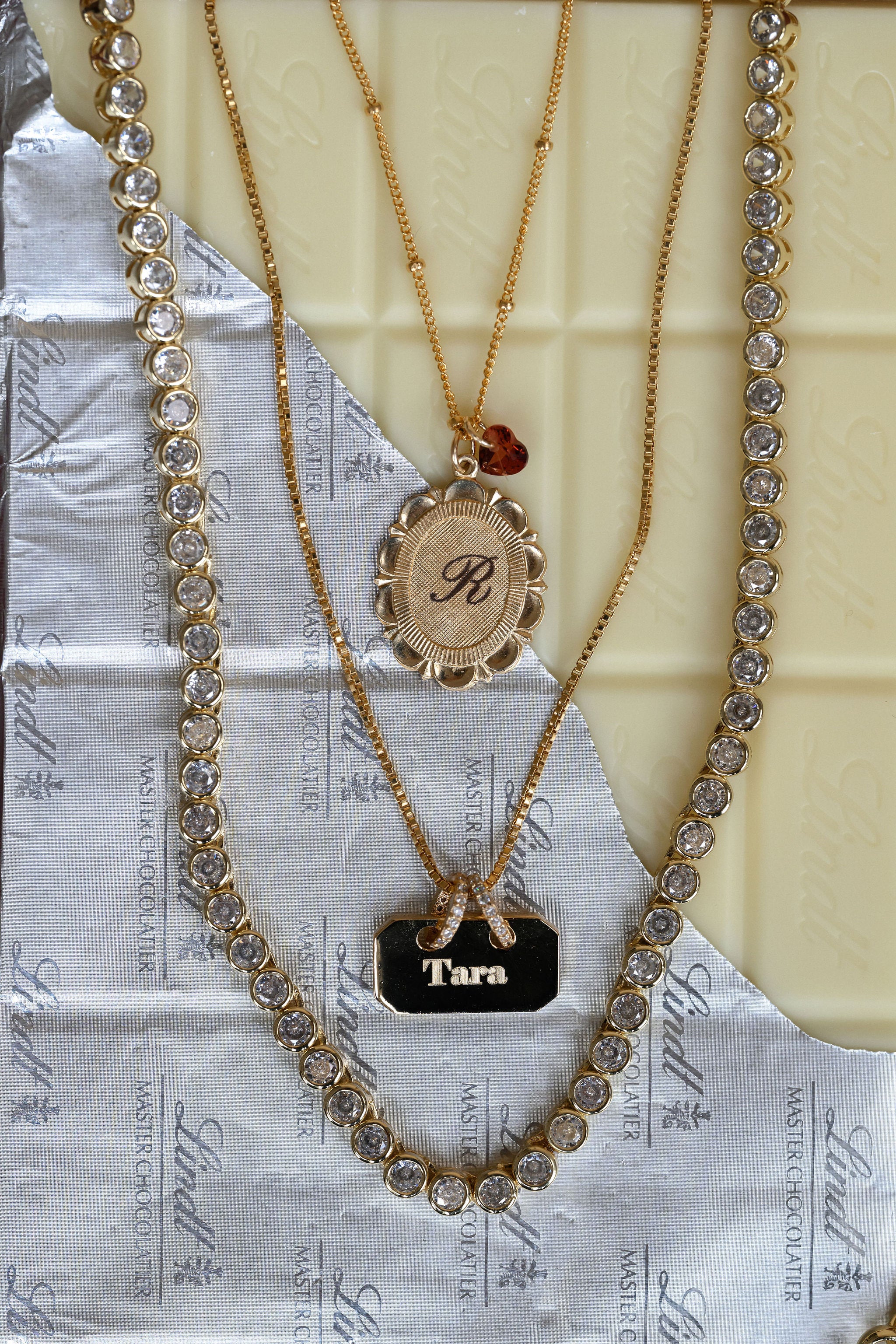 Gold necklaces with decorative elements on a textured surface