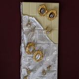 Set of gold earrings on a textured white card against a dark red background