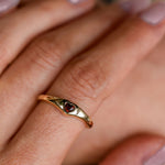 Gold ring with a red gemstone on a person's finger