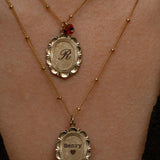 Two gold necklaces with engraved names on a person's neck.