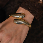 Gold bracelet on a wrist with a blurred background