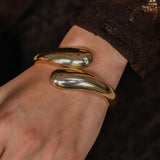 Gold bracelet on a wrist with a blurred background