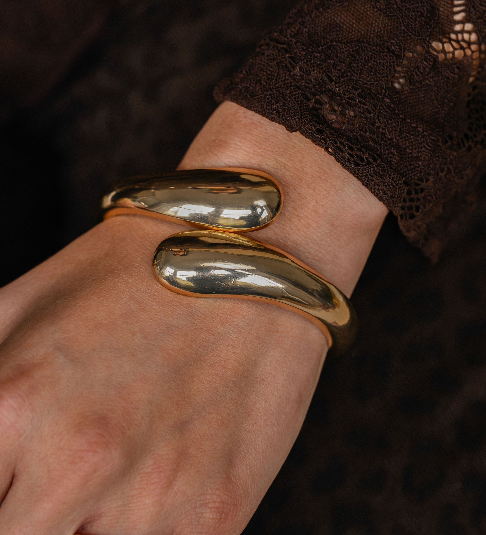 Gold bracelet on a wrist with a blurred background