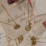 Gold necklaces with pendants on vintage letters with stamps