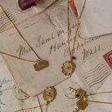 Gold necklaces with pendants on vintage letters with stamps