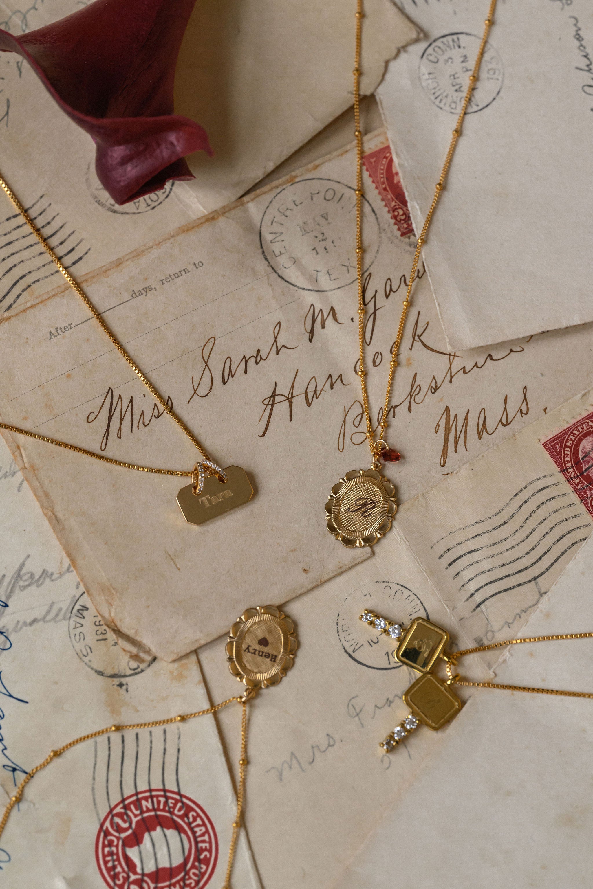 Gold necklaces with pendants on vintage letters with stamps