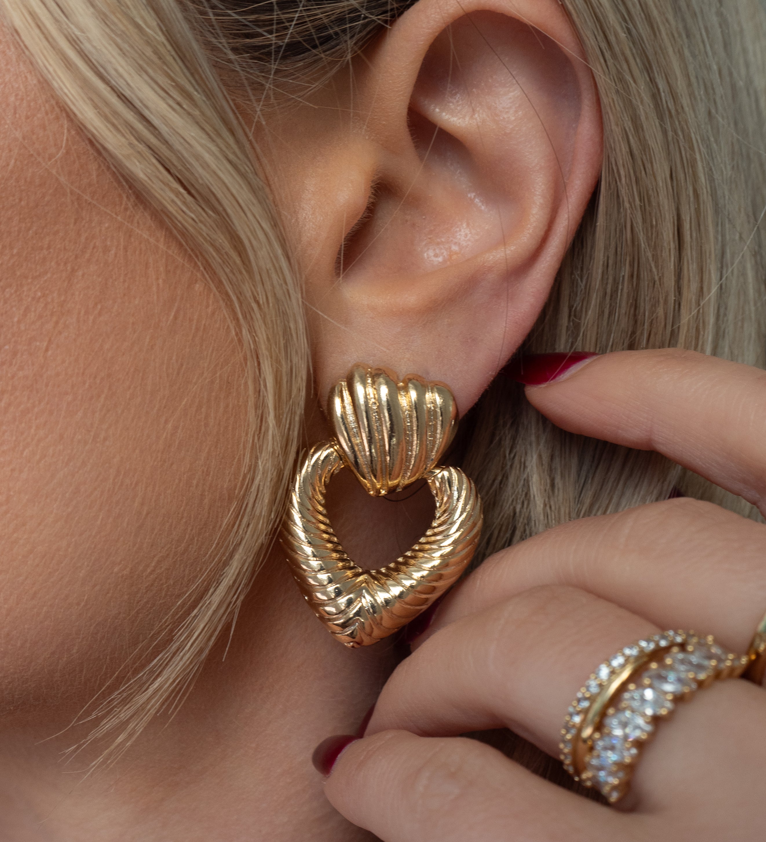 Close up of an ear with a statement heart earring