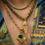 Model wearing the Pez necklace in evergreen gemstones layered with beaded strands