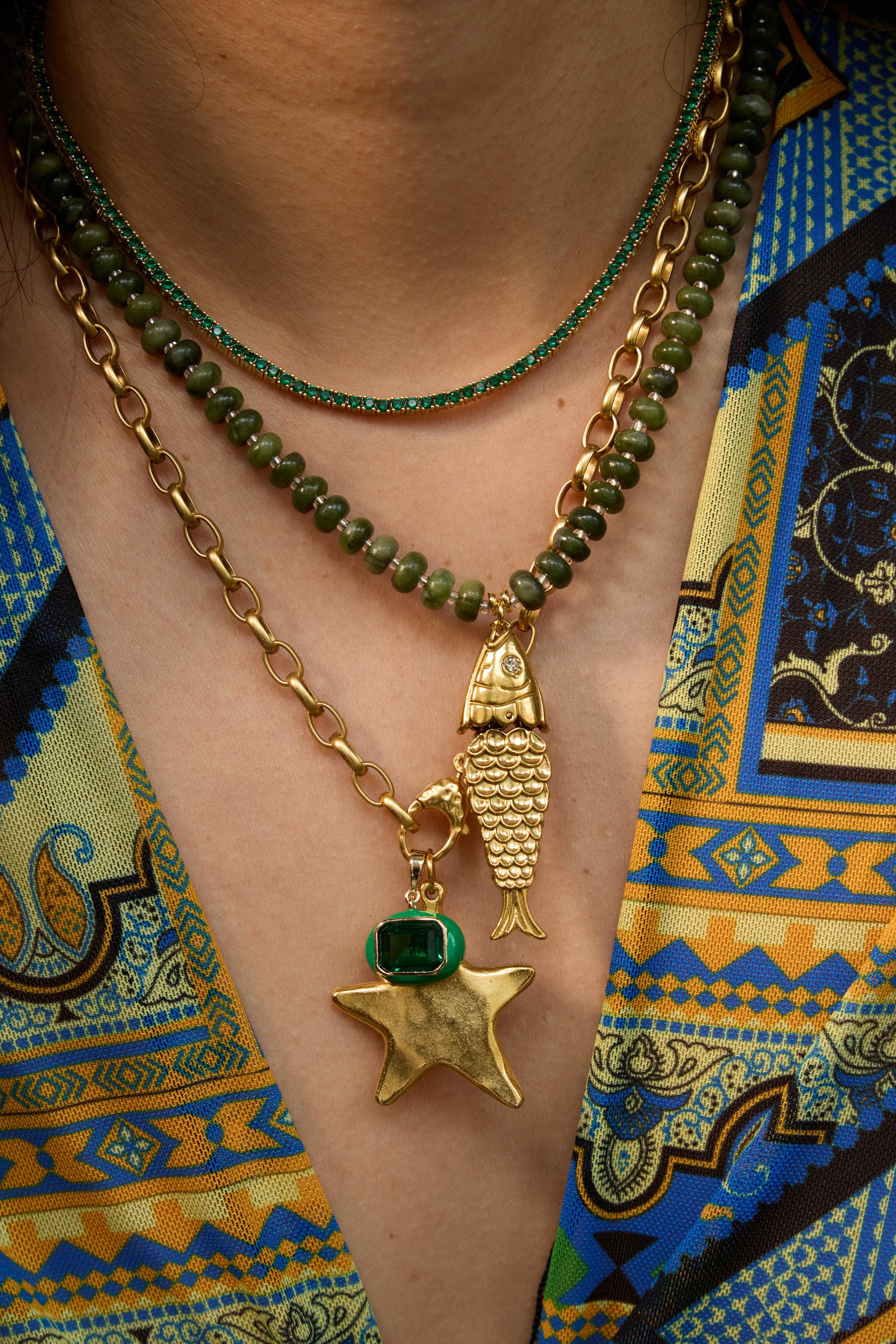 Model wearing the Pez necklace in evergreen gemstones layered with beaded strands