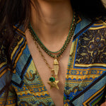 Model wearing the olive Pez gemstone necklace with a vintage fish charm