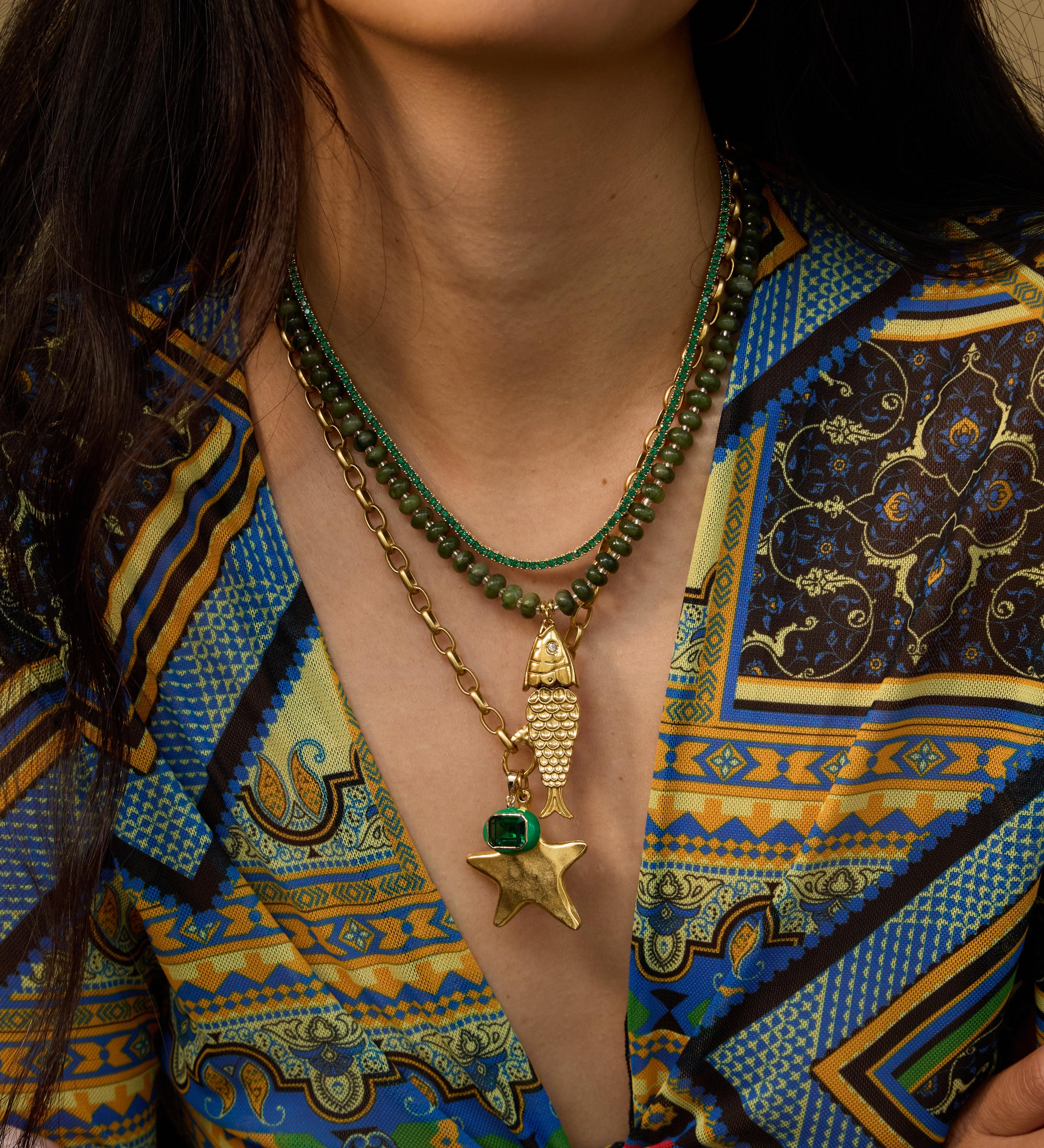Model wearing the olive Pez gemstone necklace with a vintage fish charm