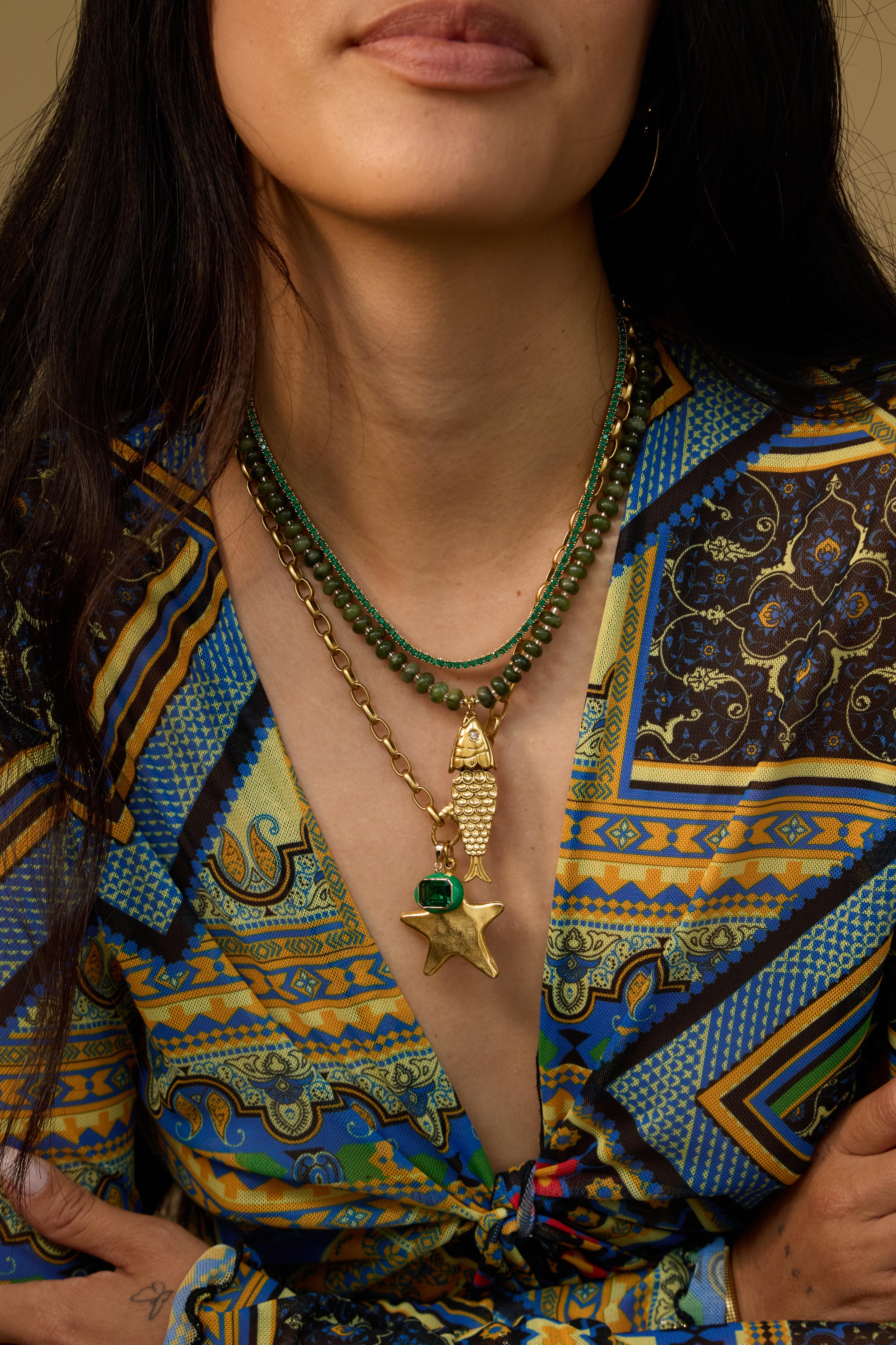 Model wearing the olive Pez gemstone necklace with a vintage fish charm