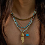 Model wearing the turquoise Pez necklace with its articulated fish charm