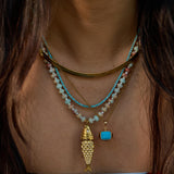 Model wearing the turquoise Pez necklace with its articulated fish charm