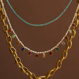 Three necklaces with different designs on a brown background