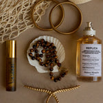 Perfume bottle, jewelry, and decorative items on a textured surface