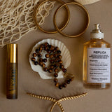 Perfume bottle, jewelry, and decorative items on a textured surface