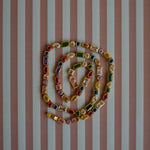 Colorful gemstone necklace on a striped background