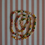 Colorful beaded necklace on a striped background