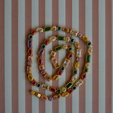 Colorful beaded necklace on a striped background