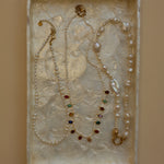 Jewelry set with pearls and gemstones on a textured surface