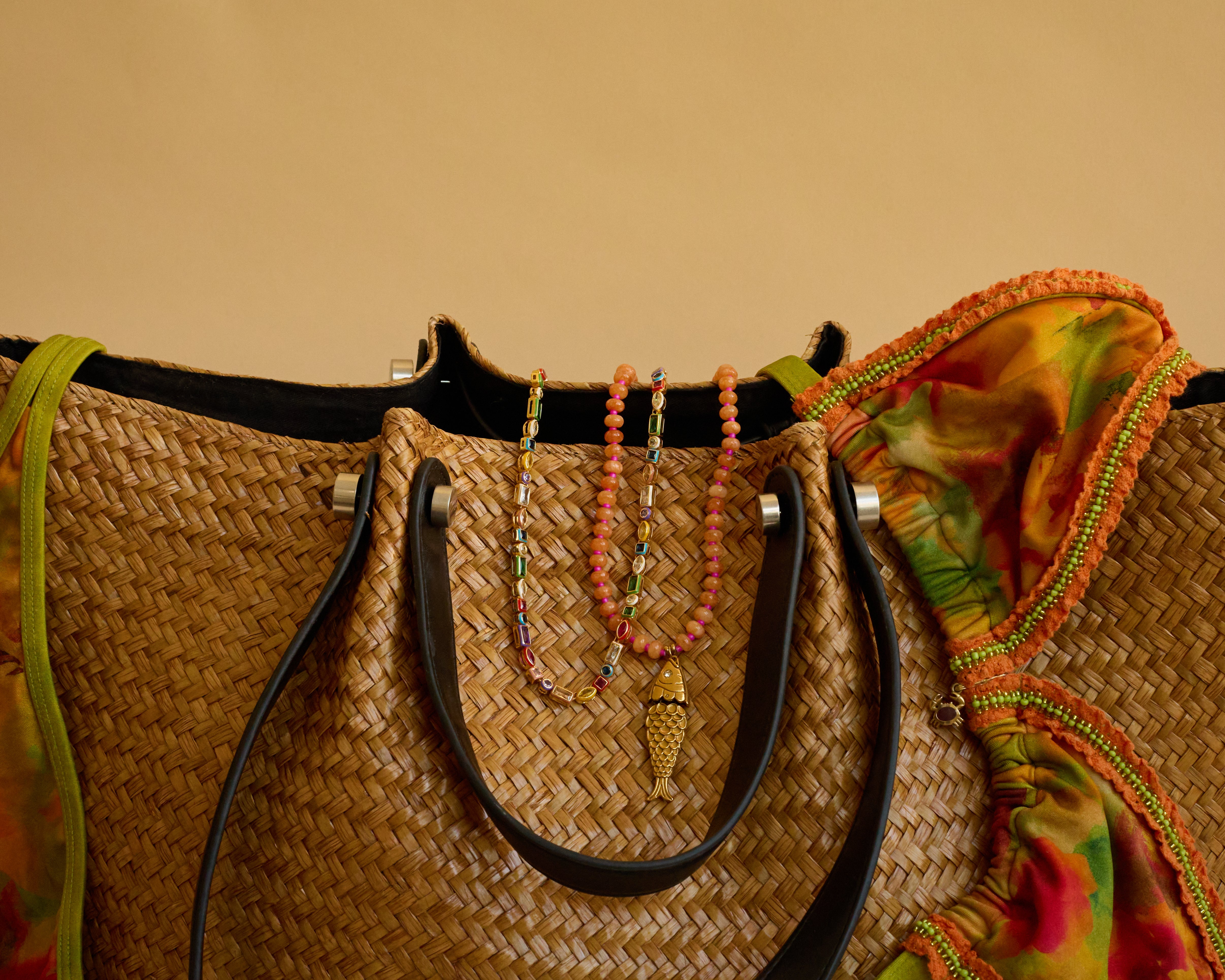 Woven bag with colorful beads and a multicolored fabric on a beige background