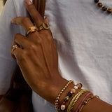 Hand with gold rings and bracelets on a white background