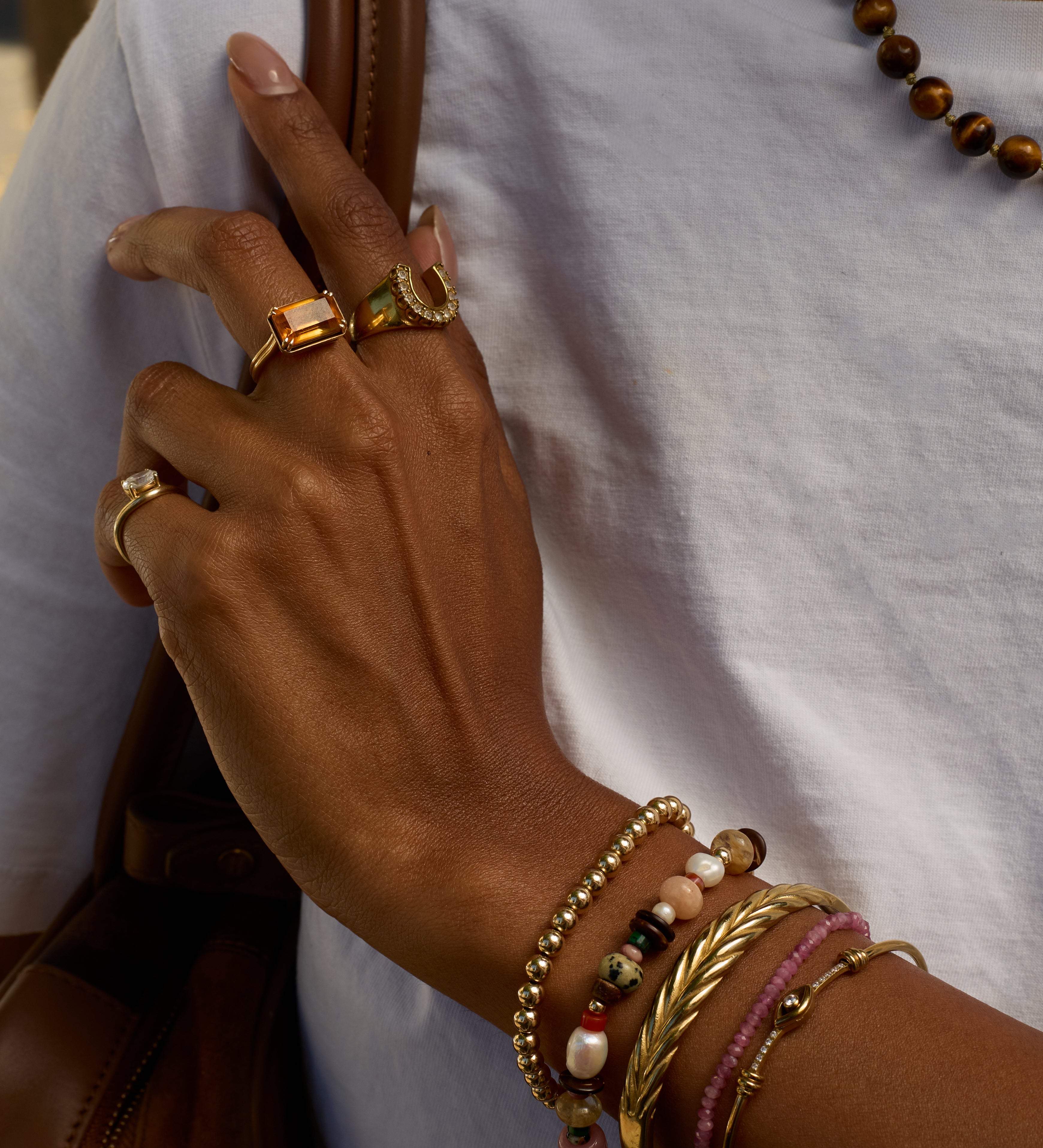 Hand with gold rings and bracelets on a white background