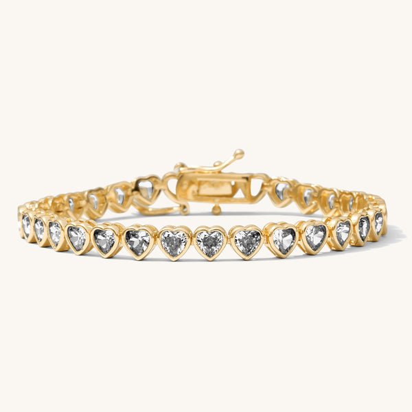 Close up of a gold bracelet with stones on a white background 