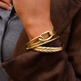 Close up of a person in a brown coat with gold bangles 