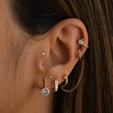 Close-up of an ear with multiple gold and diamond earrings.