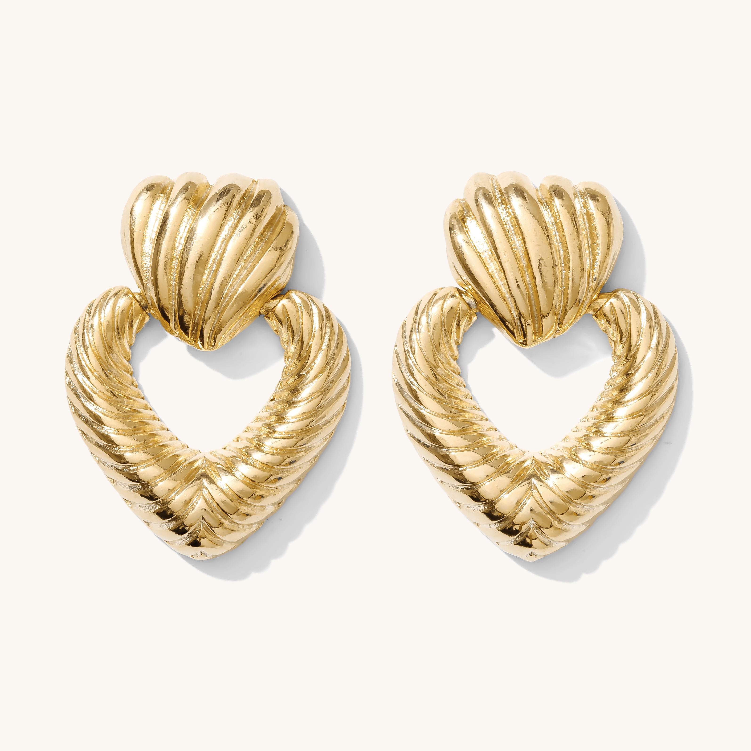 Close up of gold earrings on a white background