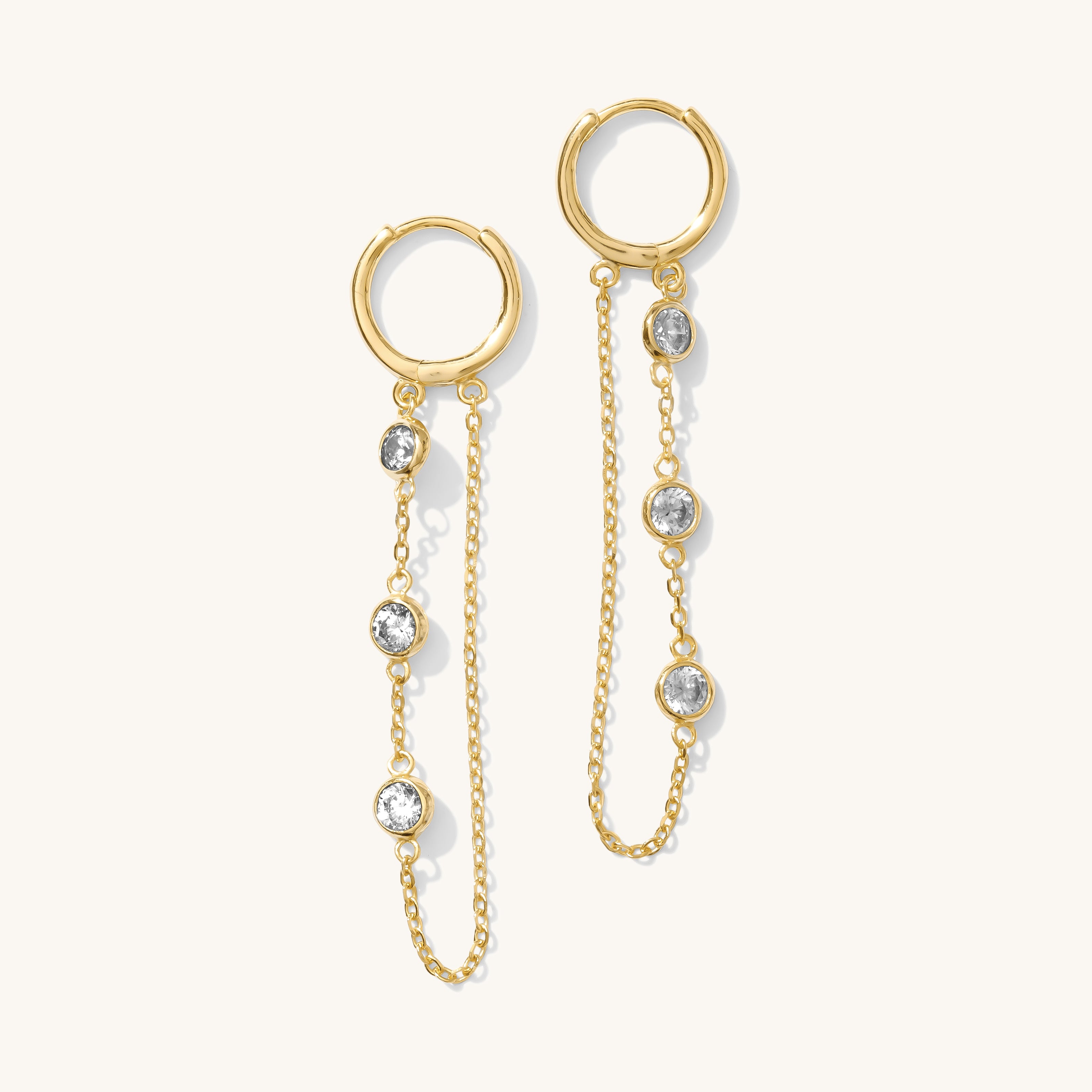 Close up of gold dangle earrings on a white background