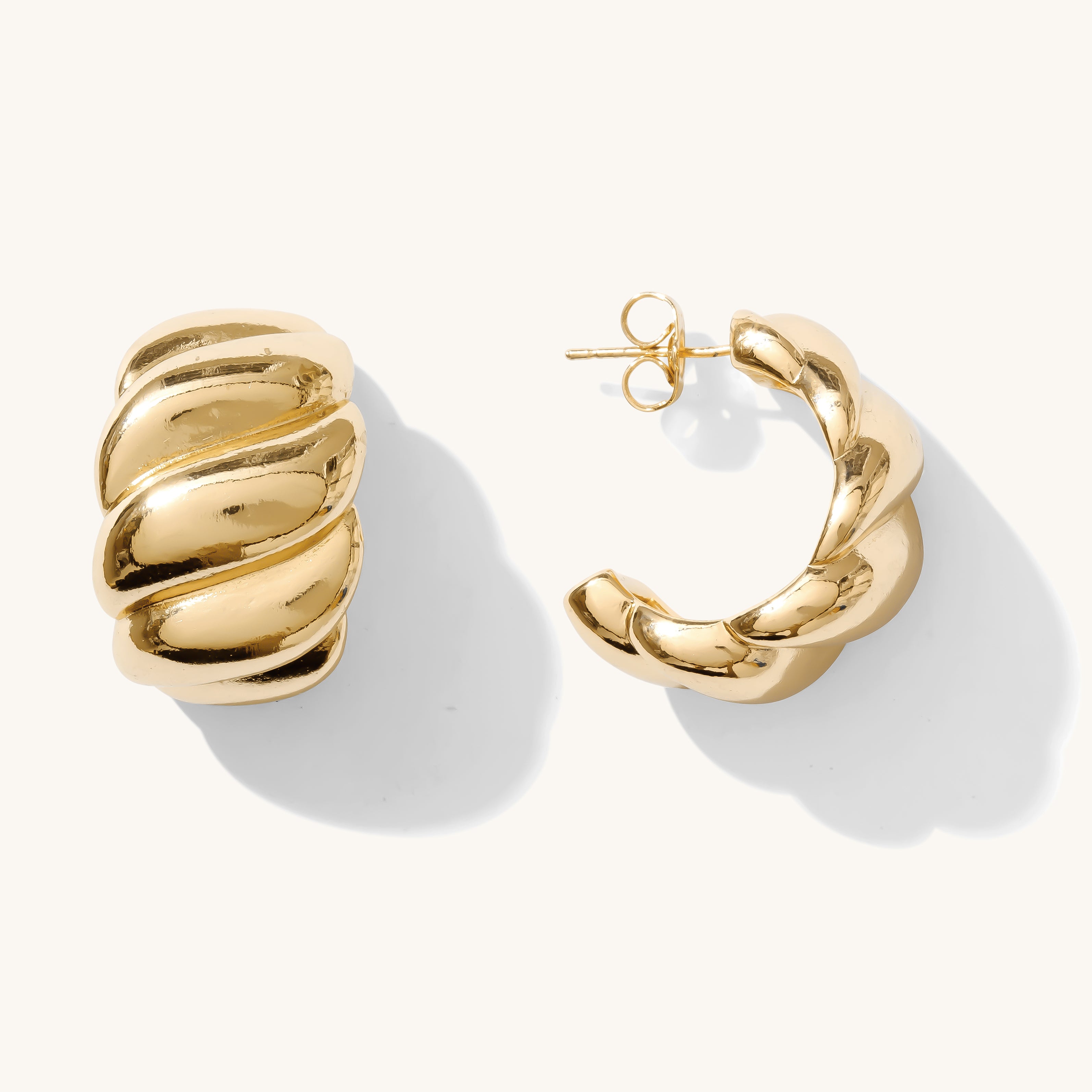 Close up of gold hoop earrings on a white background