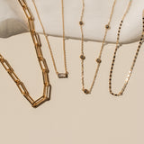 Gold necklaces displayed on a white surface