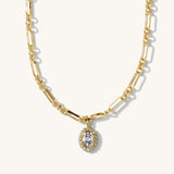 Gold chain necklace with a diamond pendant on a white background