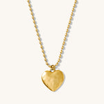 Gold heart-shaped pendant necklace on a white background